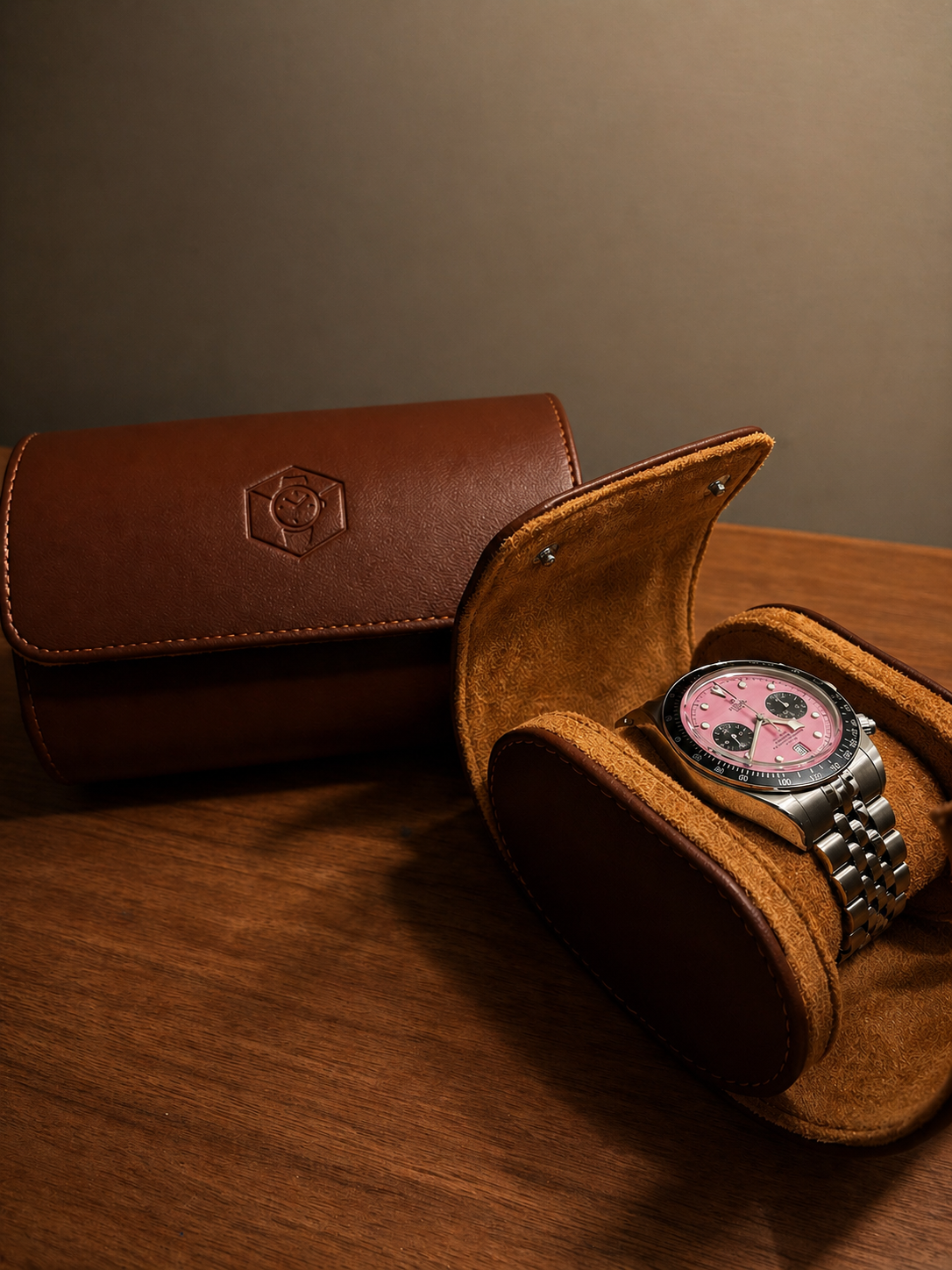 Watch roll and watch box side by side on a wooden surface